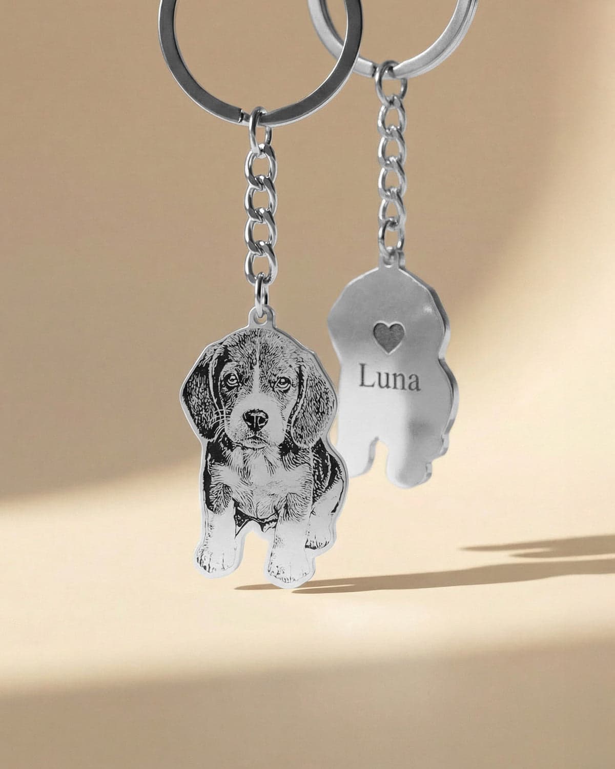 A contour-cut beagle keychain shown front and back — the engraved portrait and the reverse with a heart and the name "Luna".